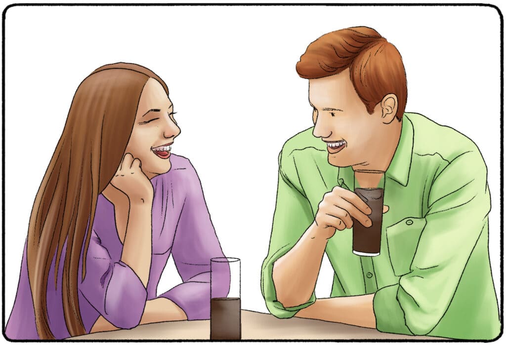 a man and a woman laughing over drinks