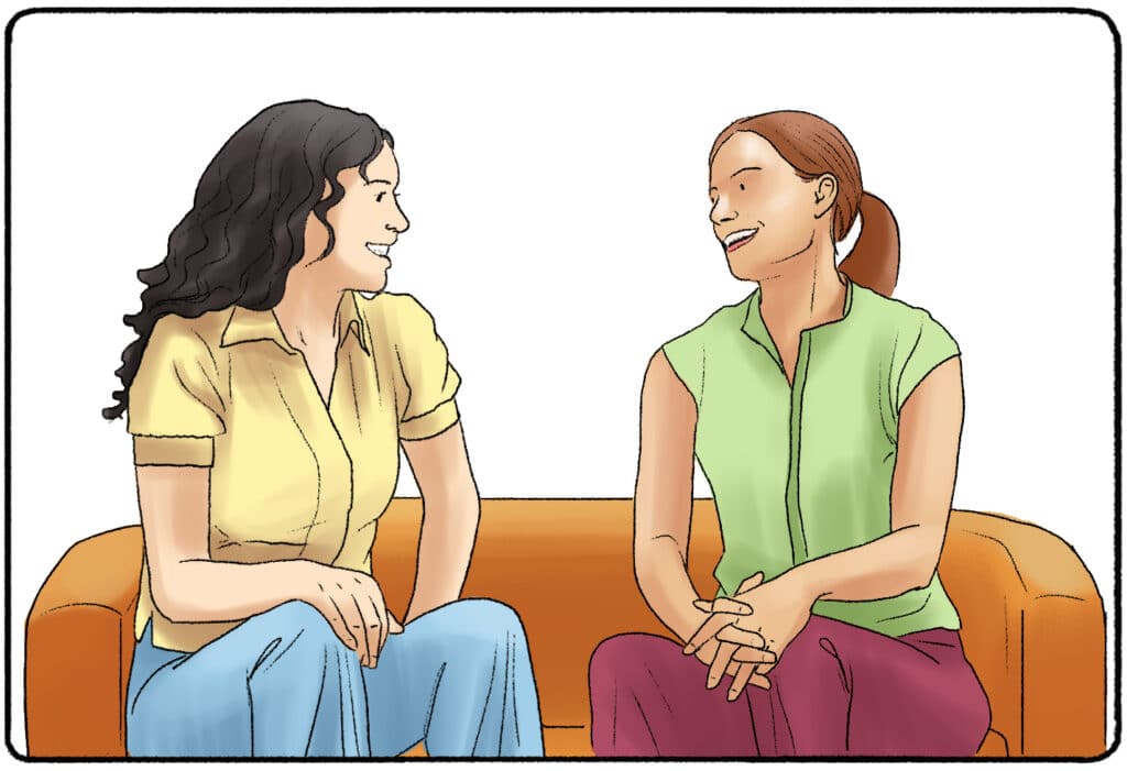 two women enjoying small talk while sitting on a couch